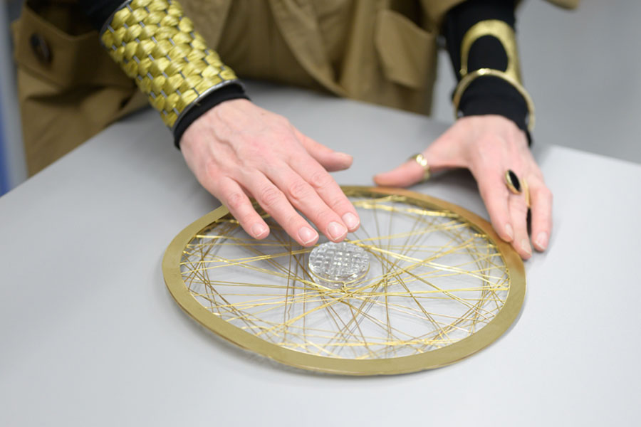 Hands touching the round metal decoration lying on the table