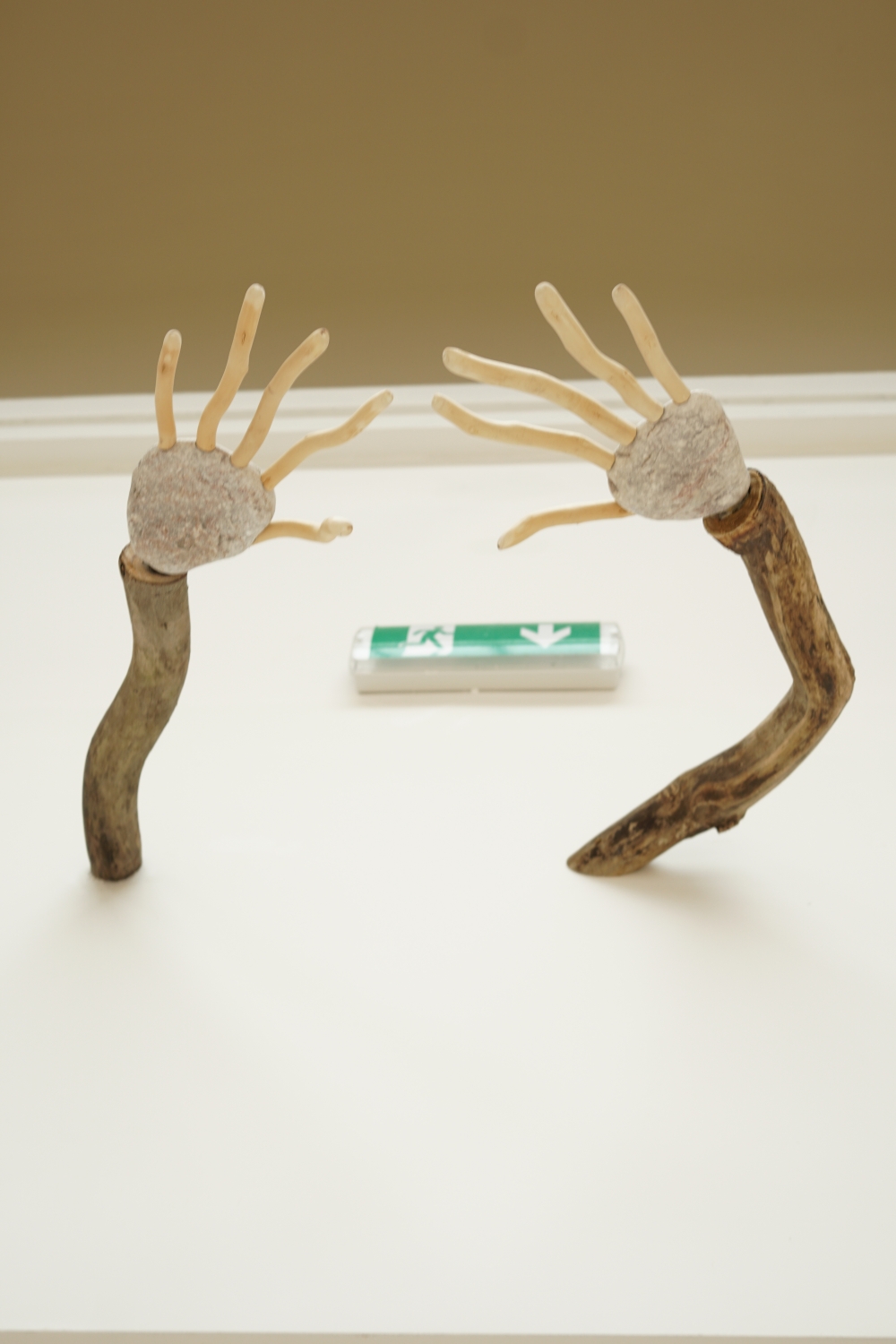 Wall-mounted object shaped like hands reaching out, featured in the “Lares and Penates” exhibition