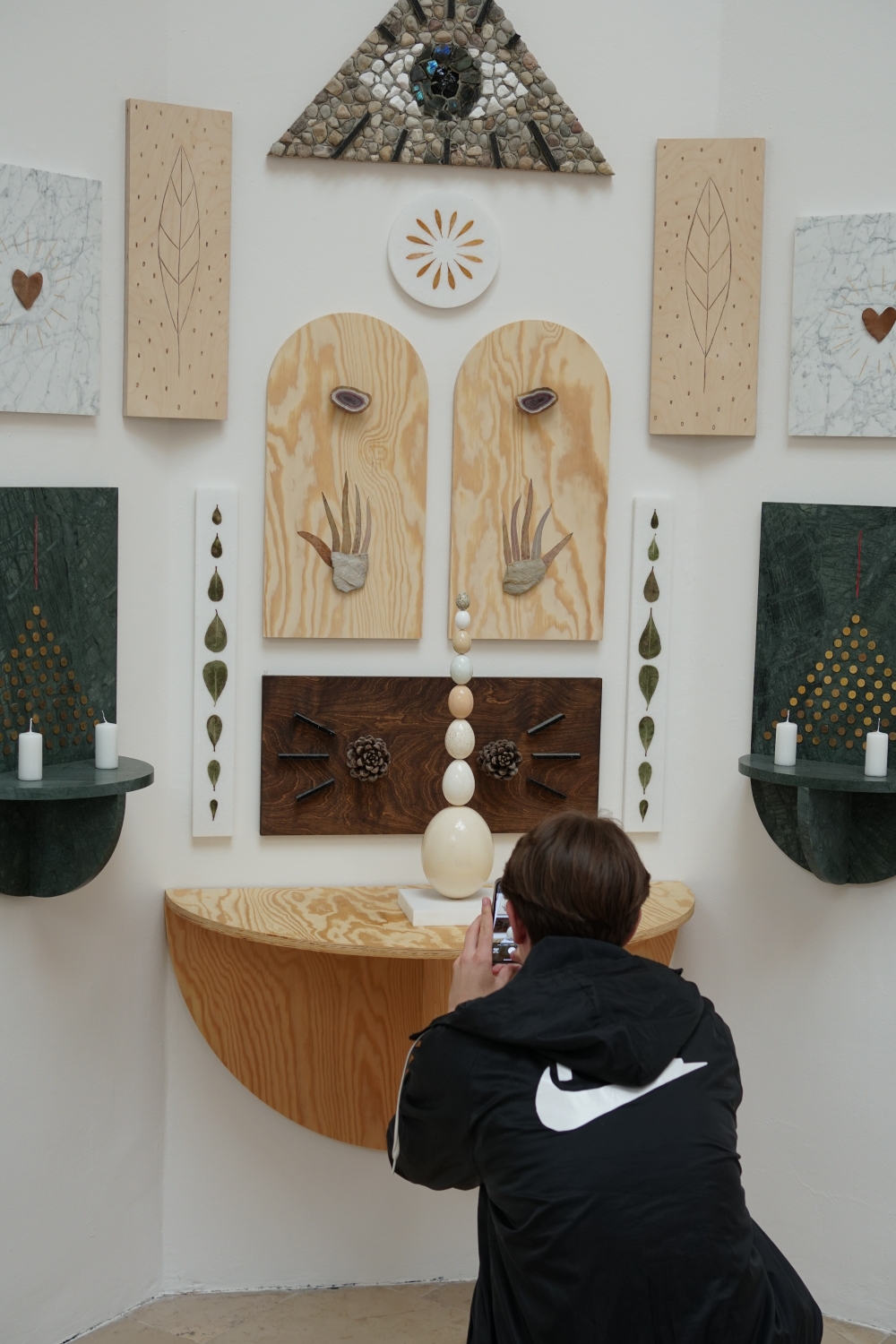 Visitor taking a photo of the objects on display at the “Lares and Penates” exhibition