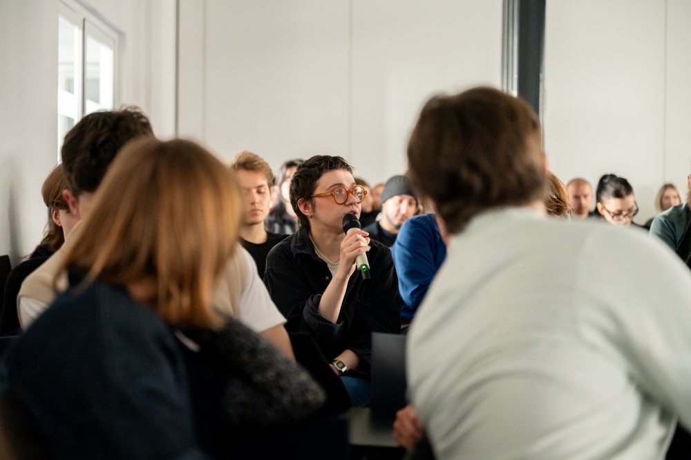 Osoba w publiczności zadaje pytanie podczas wykładu