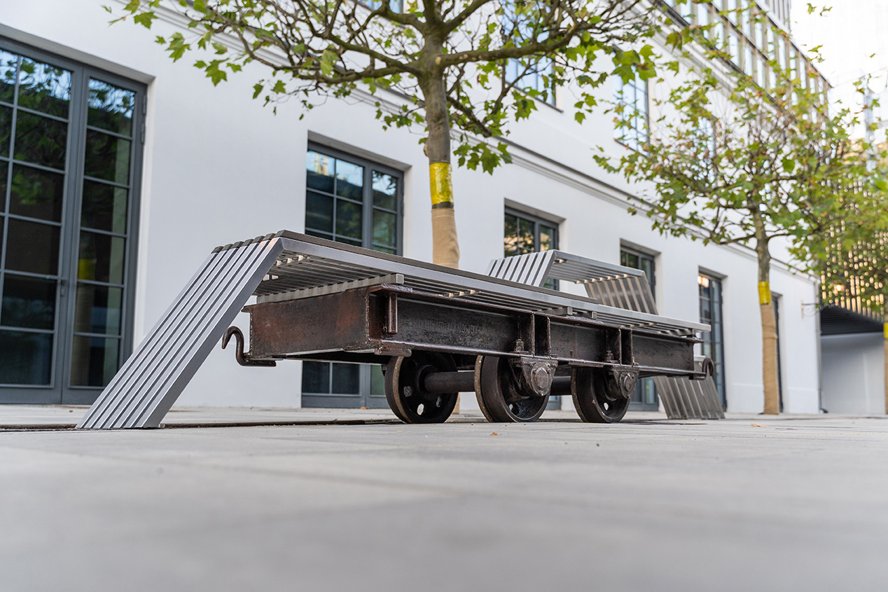 Metal vehicle on wheels standing in the courtyard.