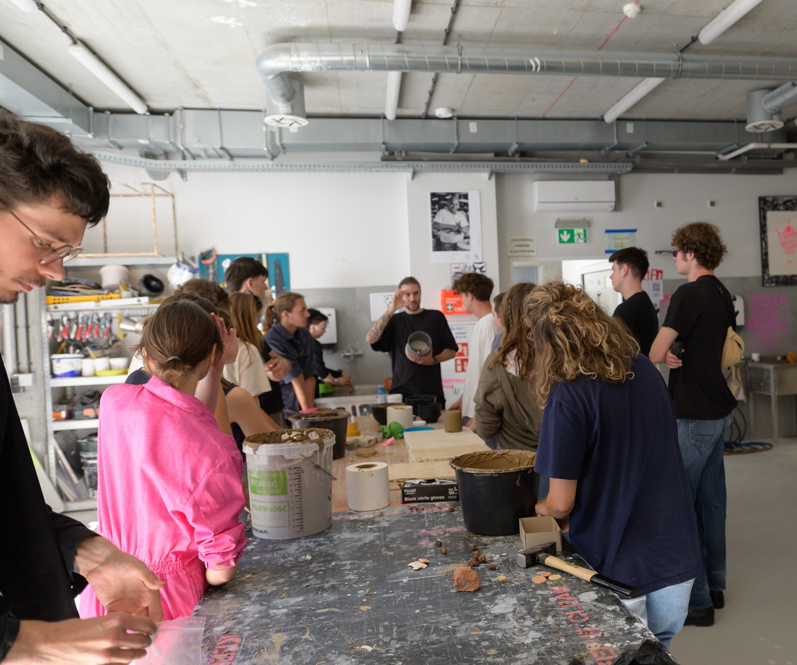 A group of students at a work table in a Ceramics Studio