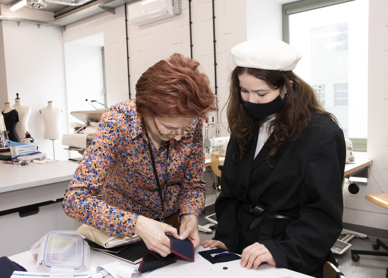 Master tailor gives sewing tips to young girl