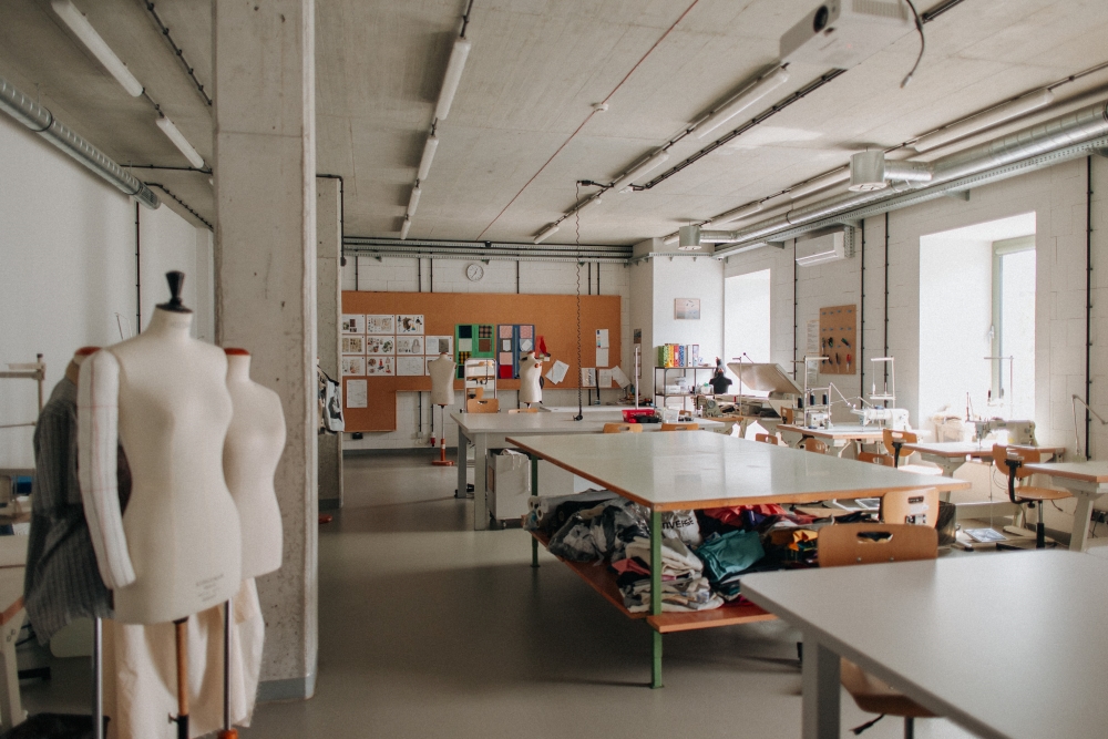 Worktables in the Sewing Workshop and fabrics stored on shelves.
