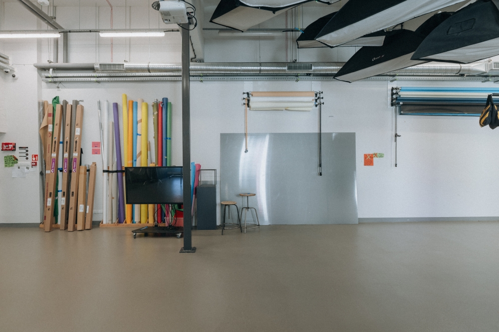 Interior of the Photo Video Studio, with rolled multicolored photography backdrops leaning against the wall in the background.