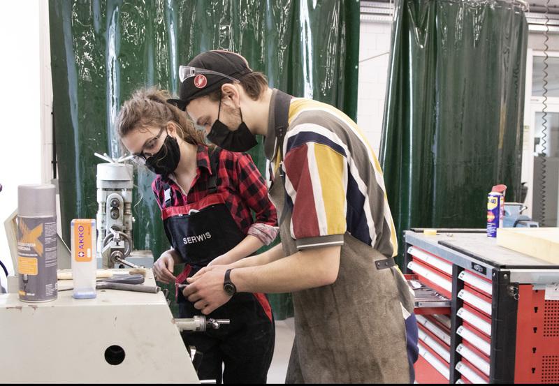 A man and a woman while working in a metal workshop