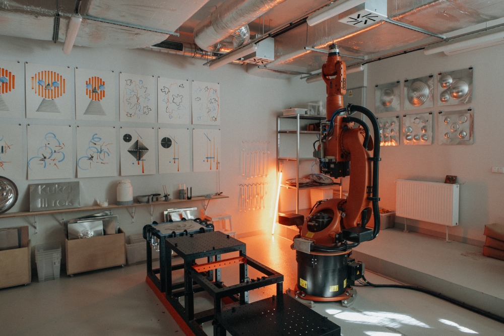 Interior of the KUKA workshop, with an indicator light on next to a large robotic arm.