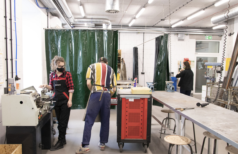 A man and a woman  working in a metal workshop shop