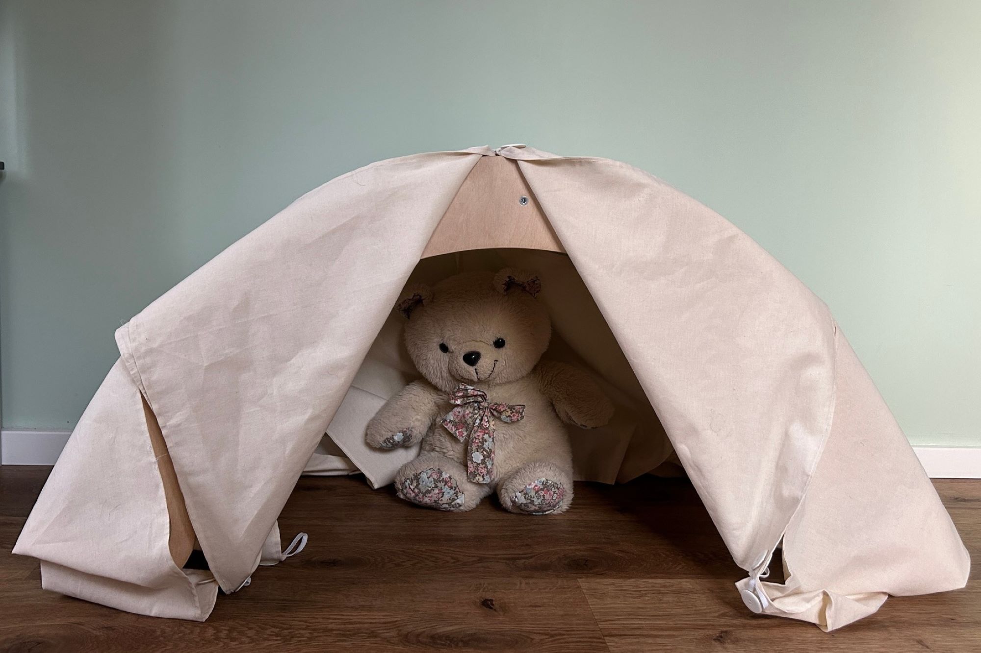 Rocker with accessories that transform it into a tent; a teddy bear is sitting inside the rocker