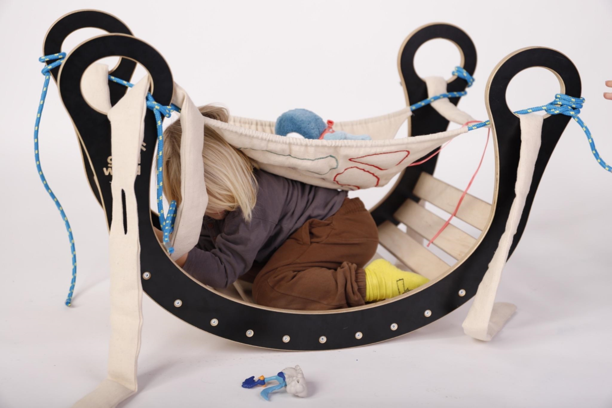 Rocker with accessories that turn it into a hideout; a small child is hiding in the rocker