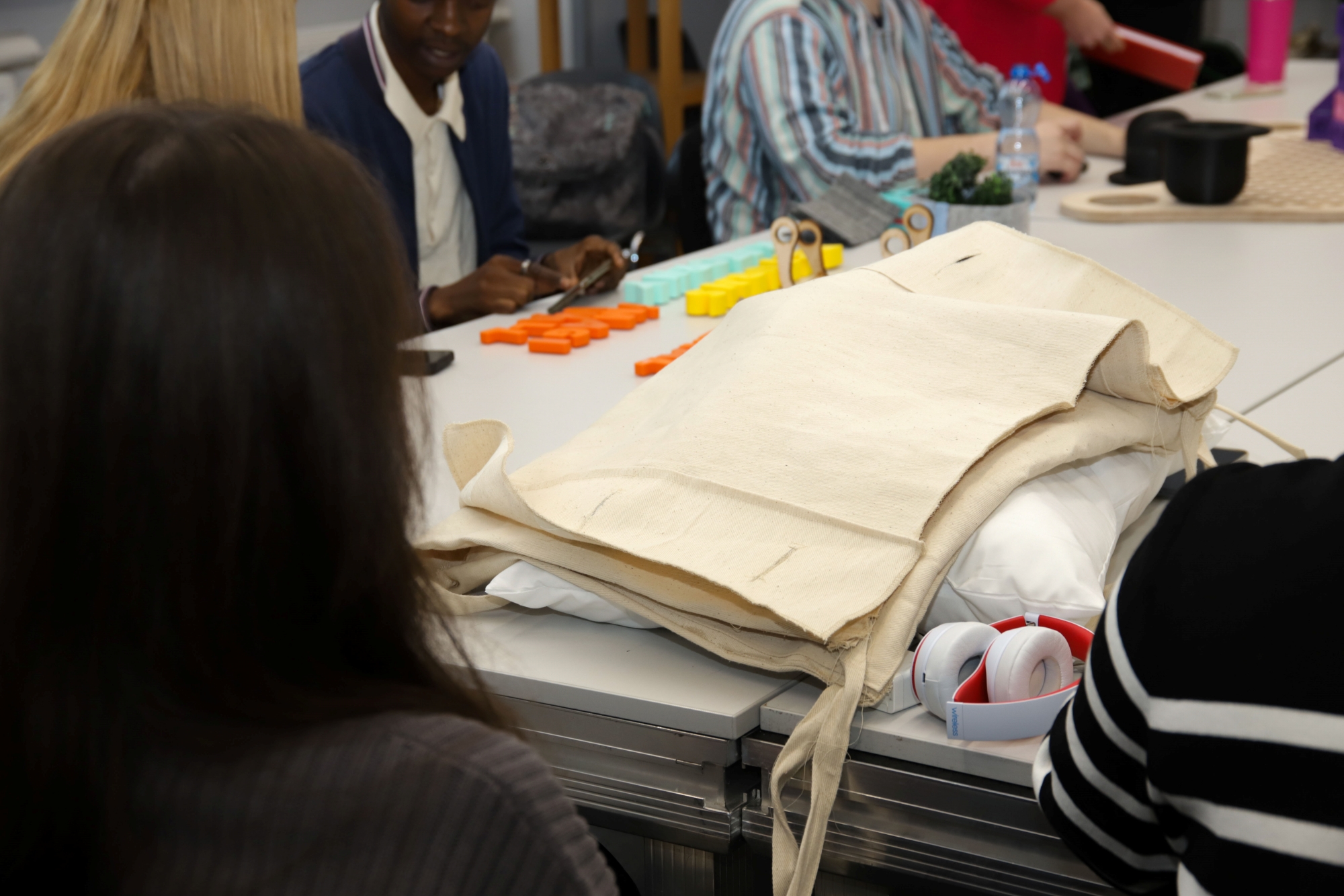 A group of students sitting around a table with various materials.