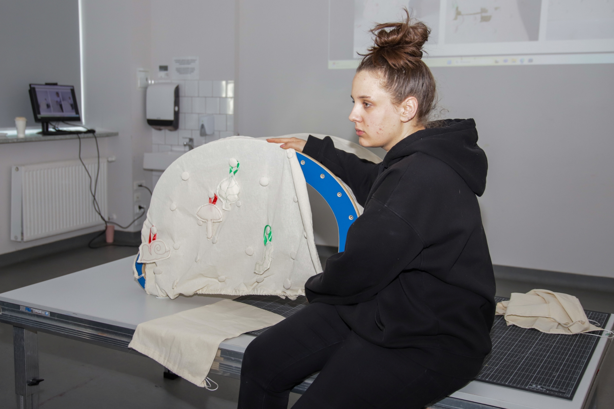 A student sitting next to a rocker used as a tent.