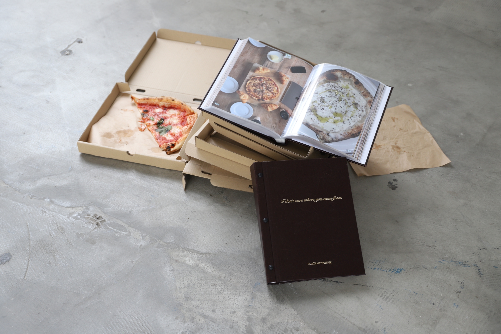 Na pudełkach po pizzy leży otwarta książka opisana w artykule
