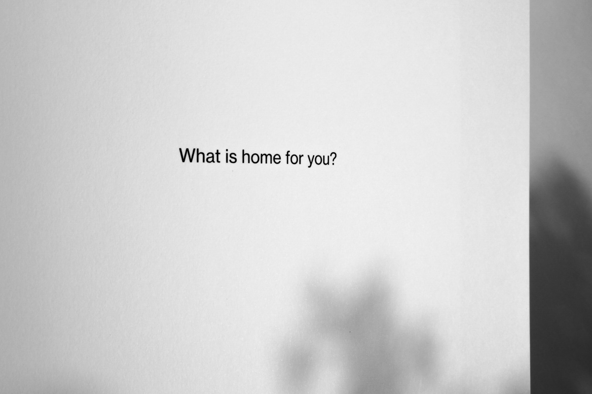 Napis na białej kartce w języku angielskim: What is home for you?